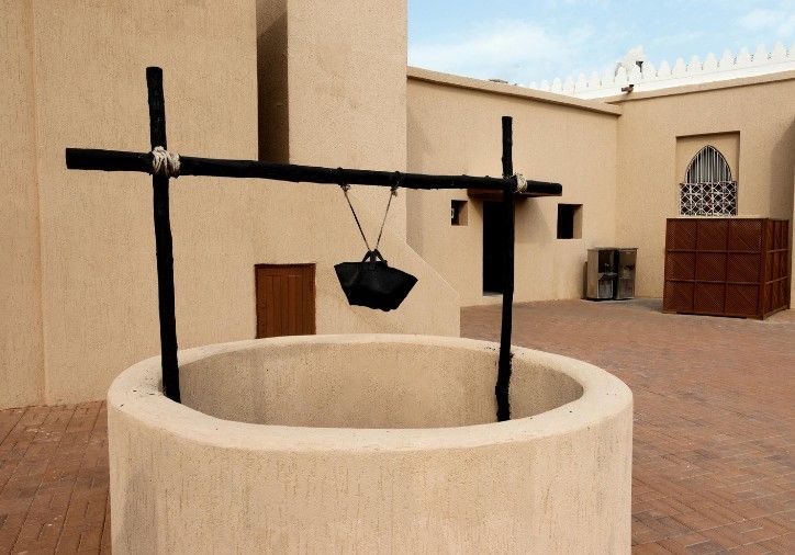 Pozo tradicional con brocal de obra y cubo colgado de una estructura de madera